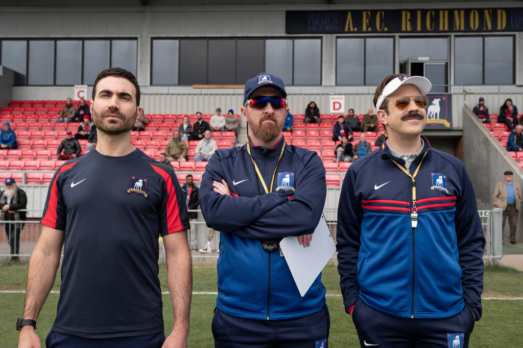 Ted Lasso: L-R Roy Kent, Coach Beard, and Ted Lasso standing on the sideline at a game