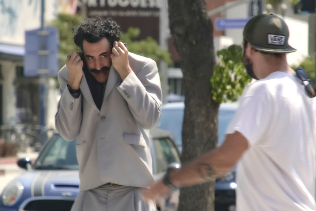 Borat pulling his suit jacket over his face to keep from being recognized