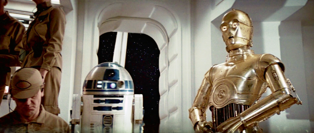 A Rebel fighter, R2-D2 and C-3PO are in frame, along with the headless bodies of two other Rebel fighters. It's an awkward shot.