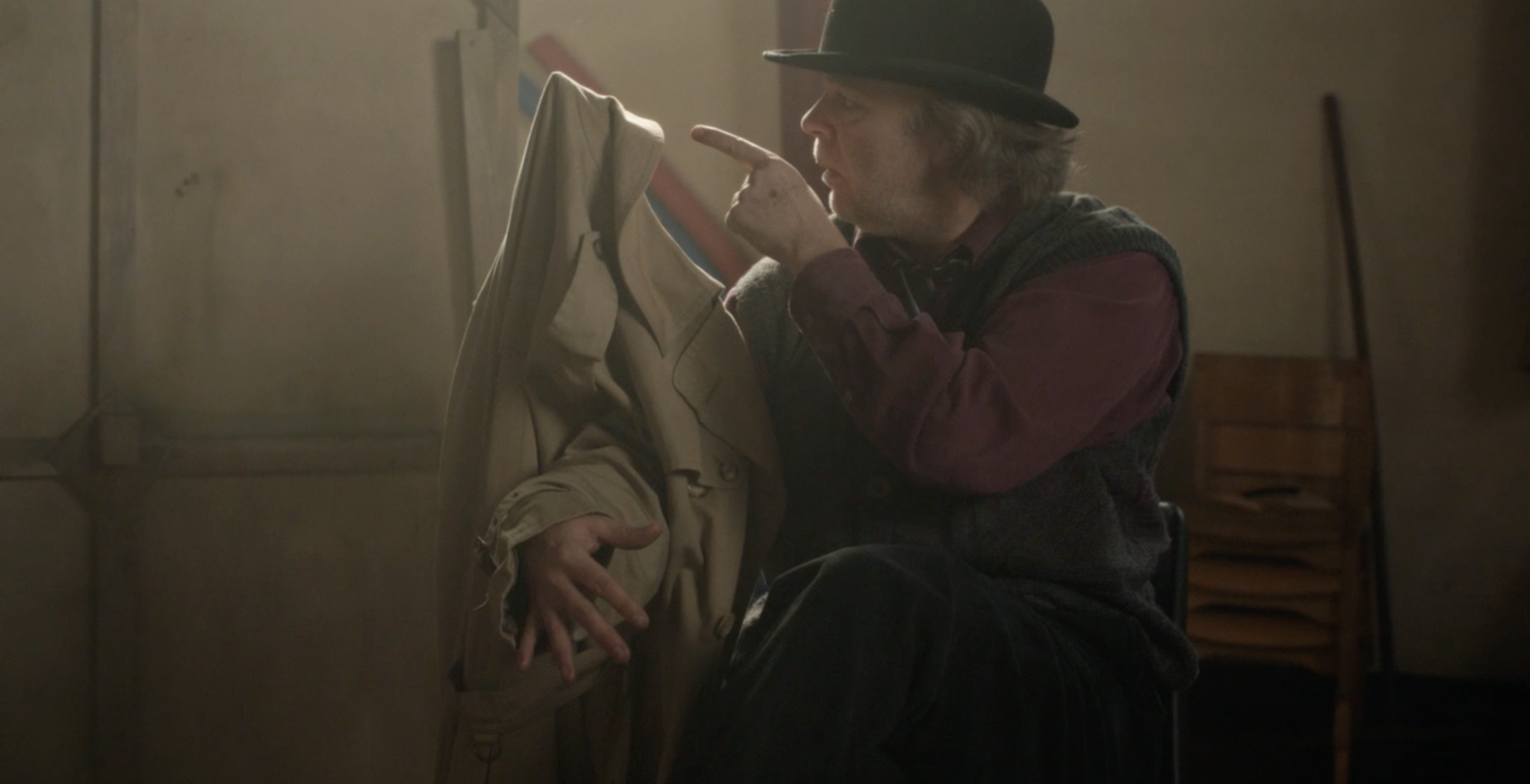 Len does a clowning act with a hat and coat.
